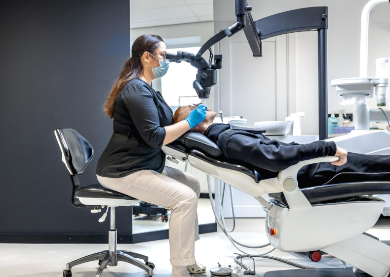 Dentista atendiendo a un paciente en una sala de tratamiento.