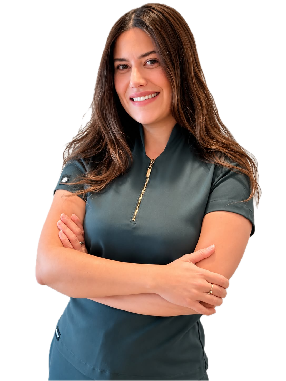 La Dra. Kamila Rodriguez sonriendo con los brazos cruzados y uniforme clínico verde oscuro.